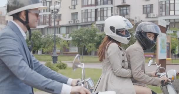Vue latérale de motards à cheval dans slowmo. Portrait d'hommes et de femmes caucasiens confiants qui partent en moto ou en scooter au ralenti. Siège social Cinema 4k ProRes. — Video