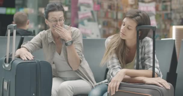 Femme caucasienne mi-adulte bâillant et mettant la tête sur le sac de voyage comme jeune touriste femelle dormant sur la valise. Portrait de voyageurs fatigués en attente de départ à l'aéroport. Siège social Cinema 4k ProRes. — Video