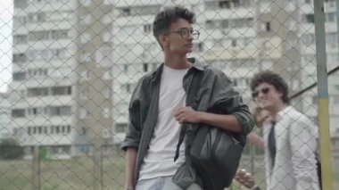 Afrika kökenli Amerikalı genç bir adamın portresi, çitlerin arkasında duran beyaz çocuklar gibi, arka planda yürüyüp ona gülüyorlar. 1980 'lerde zorbalığa uğrayan melez bir çocuk. Holigan yaşam tarzı.