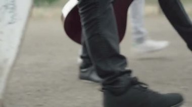 Kamera, erkek ayaklarından, yürüyen ve konuşan üç çok ırklı arkadaşın mutlu yüzlerine geçiyor. Kaykay ve gitarla dolaşan mutlu, etnik çeşitlilikte genç erkekler. 1980 'lerin yaşam tarzı.