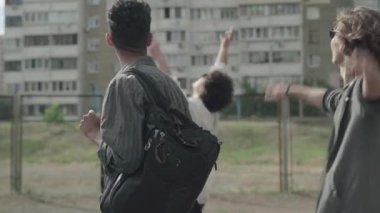 1990 'lı yılların gülen erkekleri kentte yürürken eğleniyorlar. Açık havada dinlenen Kafkas ve Afrikalı Amerikalı dostların portresi. 1980 'li yılların modası geçmiş kıyafetleri giyen adamları..