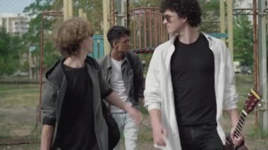 Kafkasyalı iki holiganın, utangaç, melez bir adama gülüp geçişlerinin ön görüntüsü. 1980 'lerde dışarıda gezen utangaç bir genç zorbanın portresi. Retro yaşam biçimi.