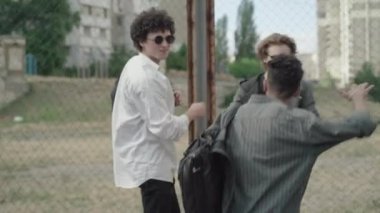Afrikalı Amerikalı lise öğrencisi 1980 'lerde açık havada beyaz arkadaşlarını selamlıyor. Kamera, neşeli genç bir adamın tel örgüdeki arkadaşlarıyla sahte kavga edişini ve gülüşünü takip ediyor. Erkek arkadaşlığı.
