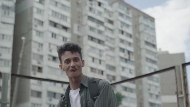 Portrait of positive young mixed-race rapper performing on urban city yard. Confident man singing rap and dancing outdoors on summer day. Retro styled guy having fun. — Stock Video