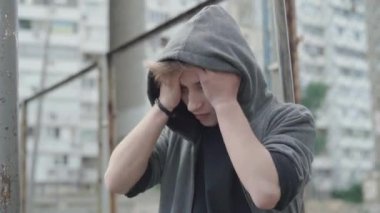 Hayal kırıklığına uğramış Kafkasyalı genç adam elleriyle başını tutuyor. Depresyonda olan yakışıklı bir adamın portresi çitin önünde dikilip düşünüyor. Morali bozuk çocuğun sorunları var..