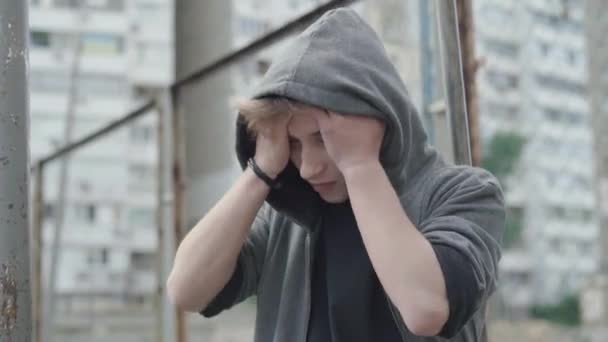 Hayal kırıklığına uğramış Kafkasyalı genç adam elleriyle başını tutuyor. Depresyonda olan yakışıklı bir adamın portresi çitin önünde dikilip düşünüyor. Morali bozuk çocuğun sorunları var.. — Stok video