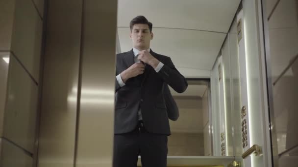 Lift door opens and elegant confident businessman walking out. Portrait of handsome young Caucasian man in formal suit leaving and elevator closing. Successful entrepreneur in business center. — Stock Video