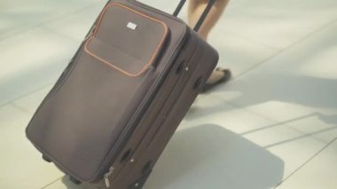 Havaalanında seyahat çantasıyla yürüyen tanınmayan bir uçuş görevlisi. Beyaz bir kadının elinde valizlerin yakın çekimi. Profesyonel hostes kalkışa hazırlanıyor. Meslek, turizm.