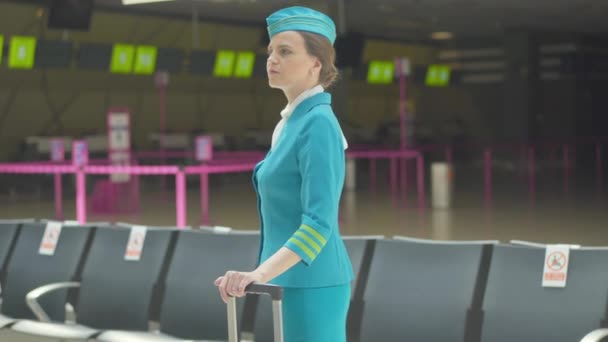 Havaalanındaki neşeli uçuş görevlisi meslektaşını selamlıyor. Kalkıştan önce ya da vardıktan sonra terminalde buluşan güzel beyaz hostes portresi. Turizm konsepti. — Stok video