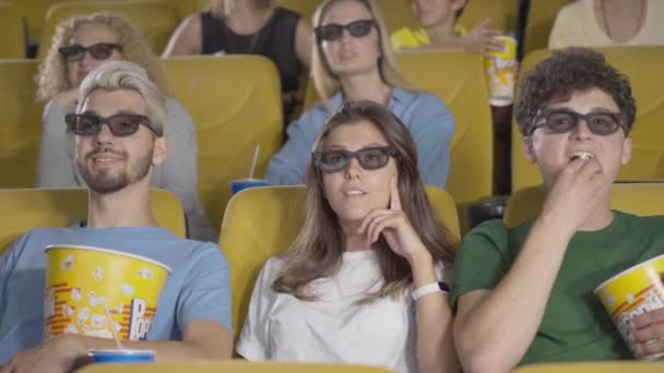 Sekelompok orang dalam gelas 3d menonton film sebagai orang yang tidak dikenal lewat depan mencegah mereka dari melihat layar. Potret audien yang tidak puas dalam perfilman. Kesenangan dan kesopanan. — Stok Video