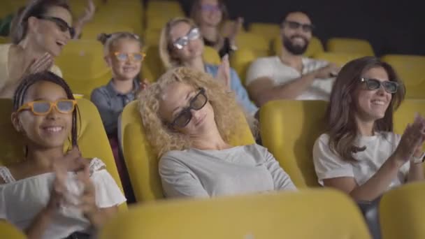 Vue d'angle de la femme caucasienne endormie dans des lunettes 3D assis au cinéma que les gens applaudissent et quittent. La caméra s'approche de la visiteuse ennuyée laissée seule au cinéma. Première ennuyeuse. — Video