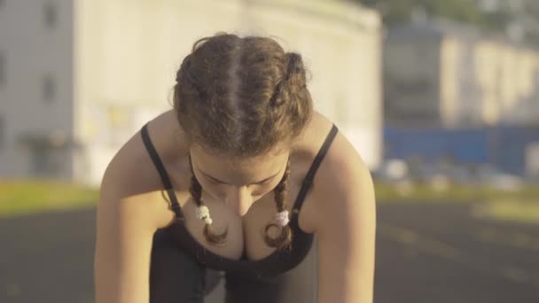 Збільшення впевненості спортсменки, що концентрується, піднімає обличчя і починає бігати. У сонячний ранок вродлива молода кавказька жінка тренується надворі. Портрет спортивної жінки, яка бігає на світанку.. — стокове відео