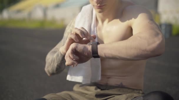 Unrecognizable perspiring sportsman checking smart watch. Confident fit Caucasian man using online app for training control. Modern technologies for workout. — Stock Video
