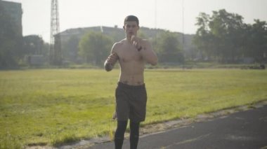 Genç Kafkas boksör sabah dışarıda antrenman yapıyor. Stadyumda hava yumruklayan yakışıklı bir adamın portresi. Güneş ışığında dövüş sanatları yapan kendine güvenen sporcuya kamera yaklaşıyor..