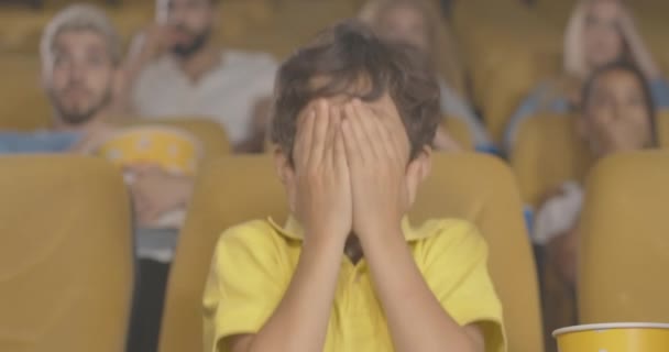 겁먹은 중동 소년이 영화에서 눈을 감고 있는 모습. 영화 극장에서 공포 영화를 보고 있는 애처로운아이. 흥분 한 아이가 화면에 나오는 장면을 보고 겁에 질려 있습니다. 시네마 4k ProRes HQ. — 비디오