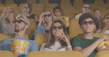 Sinemada 3D film izleyen insanların önünden geçen tanınmaz bir adam olmalarına hayran kaldım. Sinema salonundaki galadan rahatsız olan ziyaretçilerin portresi. Kızgın izleyiciler. Sinema 4k ProRes Merkezi.