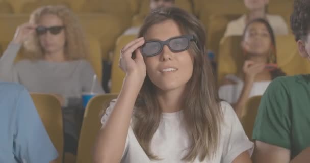 漂亮的女人在电影院戴着3D眼镜，吃爆米花，笑着。白种人游客在电影院欣赏喜剧的肖像。迷恋电影爱好者观看首映式。电影4k ProRes — 图库视频影像