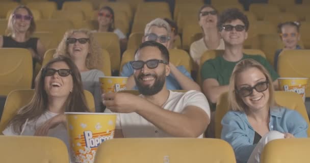 Felices visitantes del cine riendo, quitándose las gafas 3D y marchándose. Hombres y mujeres multiétnicos que se alejan después del emocionante estreno en el cine en 3D. Sede del cine 4k ProRes. — Vídeo de stock