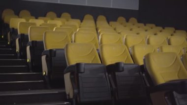 Sarı sandalyeli boş sinema salonunun geniş bir görüntüsü. Sinemada kimse yok. Eğlence merkezinin lüks iç mekanları..