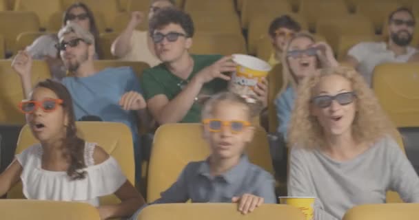 Lykkelige børn og voksne i 3D-briller ser film i biografen. Portræt af muntre børn, mænd og kvinder af forskellig etnicitet bevæger sig og smiler i biograf. Biograf 4k ProRes hovedkvarter. – Stock-video