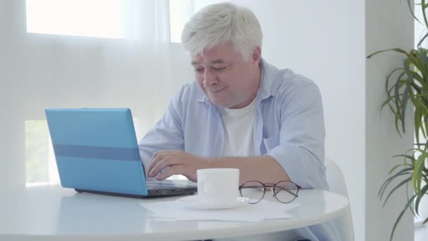 Retrato de freelancer sénior feliz trabajando en línea y contando paquete de dinero. Satisfecho feliz hombre de negocios caucásico que tiene ingresos de trabajo remoto. Trabajo independiente sobre cuarentena pandémica de Covid-19. — Vídeo de stock