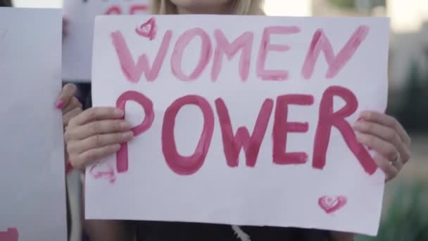 Câmera se move ao longo banners feministas em mãos ativistas. Close-up de slogans direitos das mulheres em cartazes. Pessoas irreconhecíveis protestando contra a desigualdade de gênero. Conceito de feminismo. — Vídeo de Stock