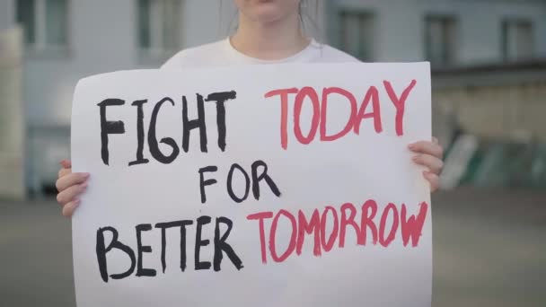 Onherkenbare vrouw die vandaag een spandoek vasthoudt met Fight for better tomorrow slogan. Jonge blanke vrouwelijke demonstrant die zich uitspreekt tegen sociale schendingen of milieuvervuiling. — Stockvideo