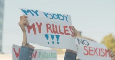 Vücudumun yakın çekimleri. Beyaz kadın ellerinde kural posterim. Cinsiyet ayrımcılığına karşı yapılan gösteride cinsiyet ayrımcılığına karşı slogan taşıyan tanınmamış genç feminist. Sinema 4k ProRes Merkezi.