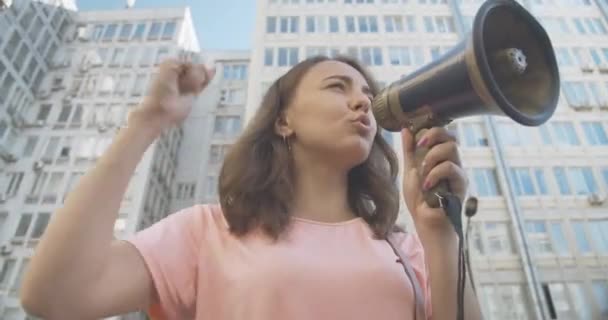 Vue du bas de la jeune femme blanche confiante criant à travers le mégaphone. Chef de manifestation encourageant la manifestation. Militant défendant les droits humains. Siège social Cinema 4k ProRes. — Video