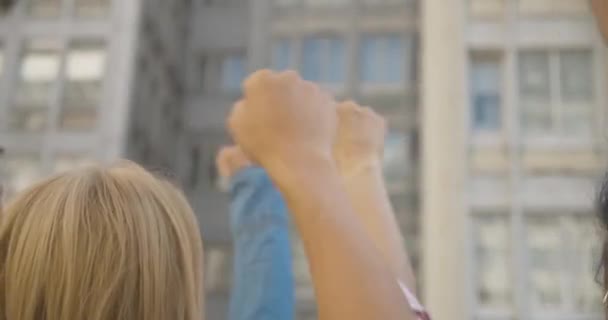 Close-up of people fists raised in air on demonstration against social inequality. Group of Caucasian activists protesting against discrimination in urban city. Cinema 4k ProRes HQ. — Stock Video