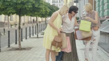 Kara Cuma günü alışverişe çıkan üç orta yaşlı müşteri. Kendine güvenen beyaz kadınların portresi şehir sokaklarında alışveriş torbalarıyla geziniyor ve konuşuyorlar. Alışveriş kolik yaşam tarzı.