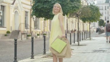 Sarı elbiseli, mutlu, orta yaşlı bir kadın alışveriş torbalarıyla dönüyor ve gidiyor. Şen şakrak sarışın Kafkasyalı alışveriş manyağı şehir sokağında Kara Cuma 'nın keyfini çıkarıyor..