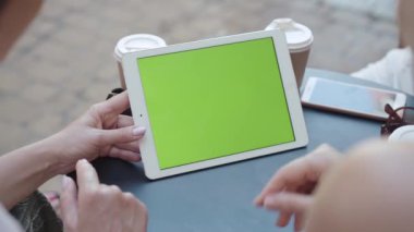 Tanınmayan üç kadın tablette krom ekran kaydırıyor. İnternette sörf yapan ya da açık kafede oturmuş internetten alışveriş yapan orta yaşlı beyaz kadınlar. Modern yaşam tarzında kablosuz teknolojiler.