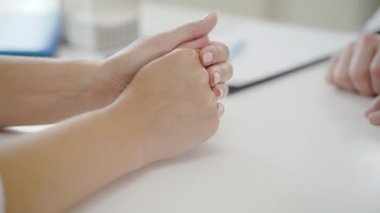 Tanımlanamayan bir doktorun kadın elini tuttuğu yakın çekim. Kimliği belirsiz beyaz kadını hastanede sakinleştiren bir doktor. Destek ve yardım kavramı.