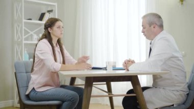 Profesyonel doktorun genç ve güzel bir bayana deneysel ilaçlar vermesi. Kronik hastalığı olan hastaya ilaç yazan kendinden emin beyaz bir adamın portresi..