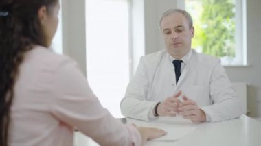 Tanımlanamayan bir kadın doktora rüşvet veriyor. Erkek rüşvetçi para alıyor, etrafa bakıyor ve cebinde dolar saklıyor. Tıbbi alanda rüşvet..