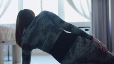 Zayıf bir kadının laptoptaki bulanık antrenörden sonra egzersizi tekrarlamasının arka görüntüsü. Covid-19 'da beyaz tenli esmer kadın sporcu eğitimi. Karantinada çalışma.