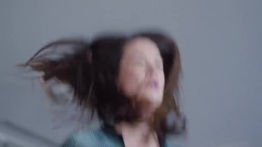 Kapalı alanda koşan mutlu güzel bir kadının yakın plan görüntüsü. Kendine güvenen beyaz kadın koşucunun portresi spor salonunda ya da evde gülümsüyor. Pozitif ince bayan egzersiz yapıyor..