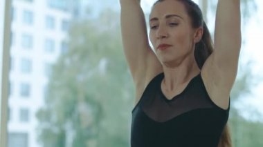 Kendine güvenen gülümseyen bir kadının nefes egzersizi yaptığı yakın plan. Spor salonunda pratik yapan güzel beyaz kadın yogi portresi. Sporcu kadın içeride eğitim görüyor..