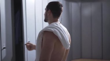 Spor salonunda idmandan sonra soyunan iki genç sporcu. Kendine güvenen beyaz adamlar dolapları açar ve giyinir. Eğitimden sonra atletik çocuklar. Güç ve erkeklik kavramı.