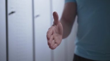 Soyunma odasında iki beyaz sporcunun el sıkışması. Tanımlanamayan kendine güvenen adamlar soyunma odasında çift egzersizi yaptıktan sonra el sıkışıyor. Eğitim ve spor konsepti.