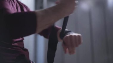 Soyunma odasında bileğine bandaj saran tanınmamış boksör. Güçlü beyaz sporcu soyunma odasında dövüşmeye hazırlanıyor. Spor salonunda antrenmandan önce kendine güveni olan bir adam değişiyor..