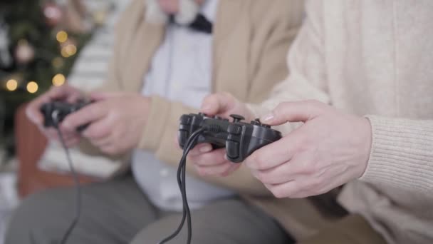 Homme et femme âgés méconnaissables jouant sur des consoles de jeu. Actif joyeux mari caucasien et femme s'amuser à la maison la veille de Noël. Concept de style de vie. — Video