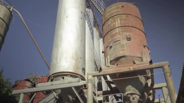 Silos pour charger du ciment par temps ensoleillé à l'extérieur. Vue d'ensemble du stockage de ciment en vrac dans des tours en acier inoxydable. Construction sur site de fabrication du béton. — Video