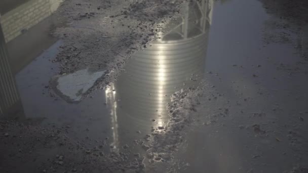 Riflessione in pagaia di acciaio inox silo stoccaggio cemento. Enorme torre per lo stoccaggio di calcestruzzo all'aperto nella giornata di sole che si riflette in acqua. Costruzione di impianti di produzione. — Video Stock