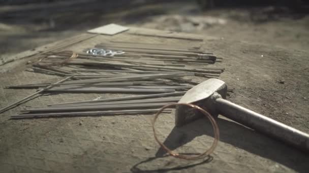 Close-up of hammer and nails lying on wooden surface outdoors. Working tools in sunlight. Manual work concept. — Stock Video