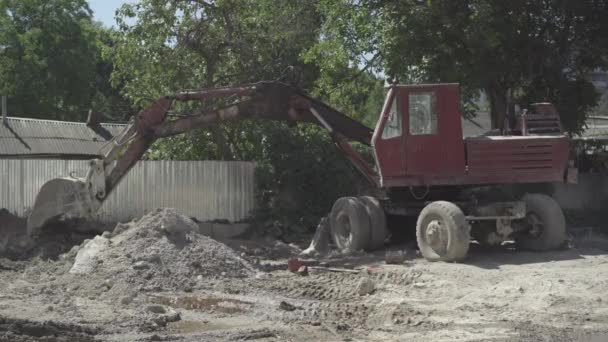 Široký záběr zanedbávaného traktoru s vědrem stojícím venku na opuštěném místě výroby. Poškozené průmyslové stroje na zničené továrně nebo závodě. — Stock video