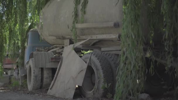 Terk edilmiş üretim alanındaki çimento karıştırıcı kamyonunun arka açısı. Gün ışığında terk edilmiş nakliye aracı duruyor. İhmal edilen fabrikadaki makineler. — Stok video