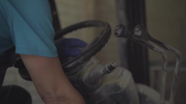 Mãos masculinas caucasianas em luvas de trabalho girando volante de transporte industrial. Motorista irreconhecível caminhão de condução na fábrica ou planta. — Vídeo de Stock