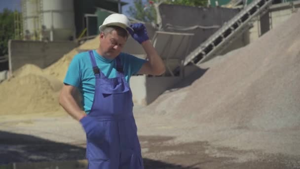 Retrato del trabajador agotado de la fábrica quitándose el casco de seguridad, limpiando la frente con la mano y saliendo. Hombre cansado empleado caucásico que trabaja en la fabricación o la construcción al aire libre. — Vídeos de Stock